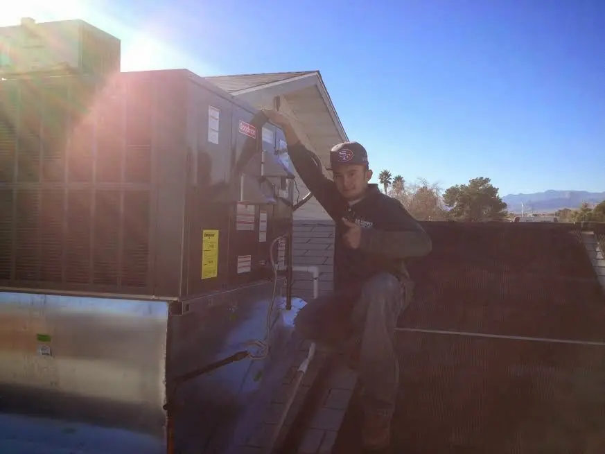 HVAC technician performing AC Tune-Up on a rooftop unit in Argentine